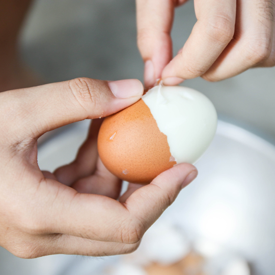 brown egg being peeled